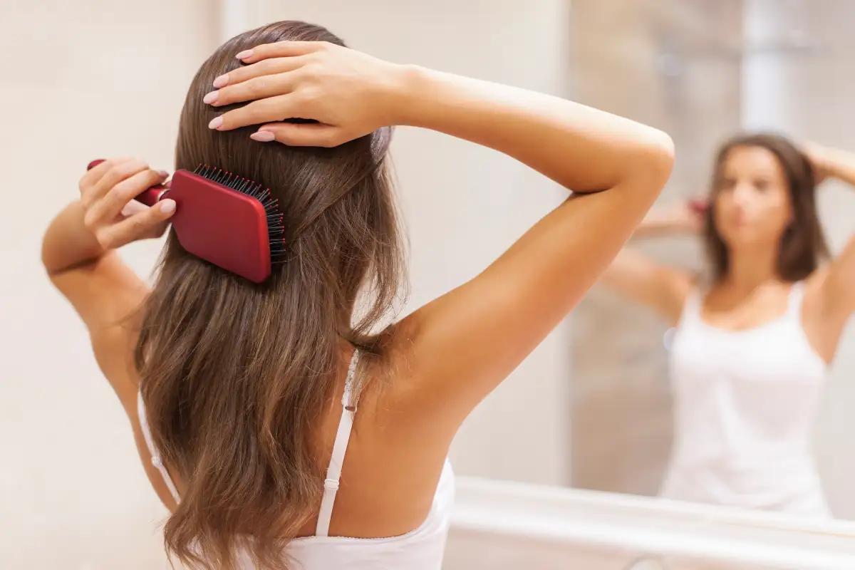Kobieta czesząca puszące się włosy