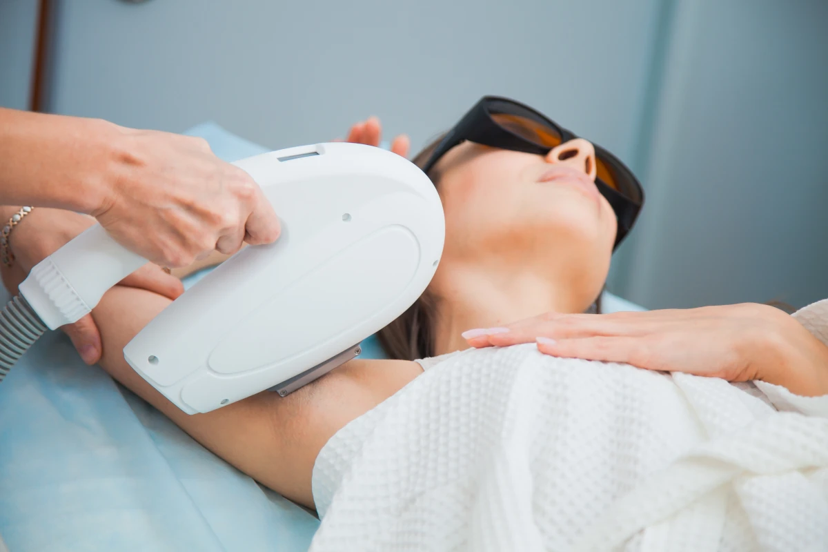 kobieta leży podczas zabiegu laserowego usuwania włosów pod pachami
