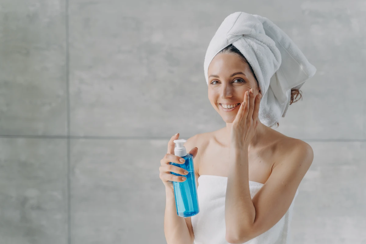 kobieta myje twarzy przy użyciu wody micelarnej