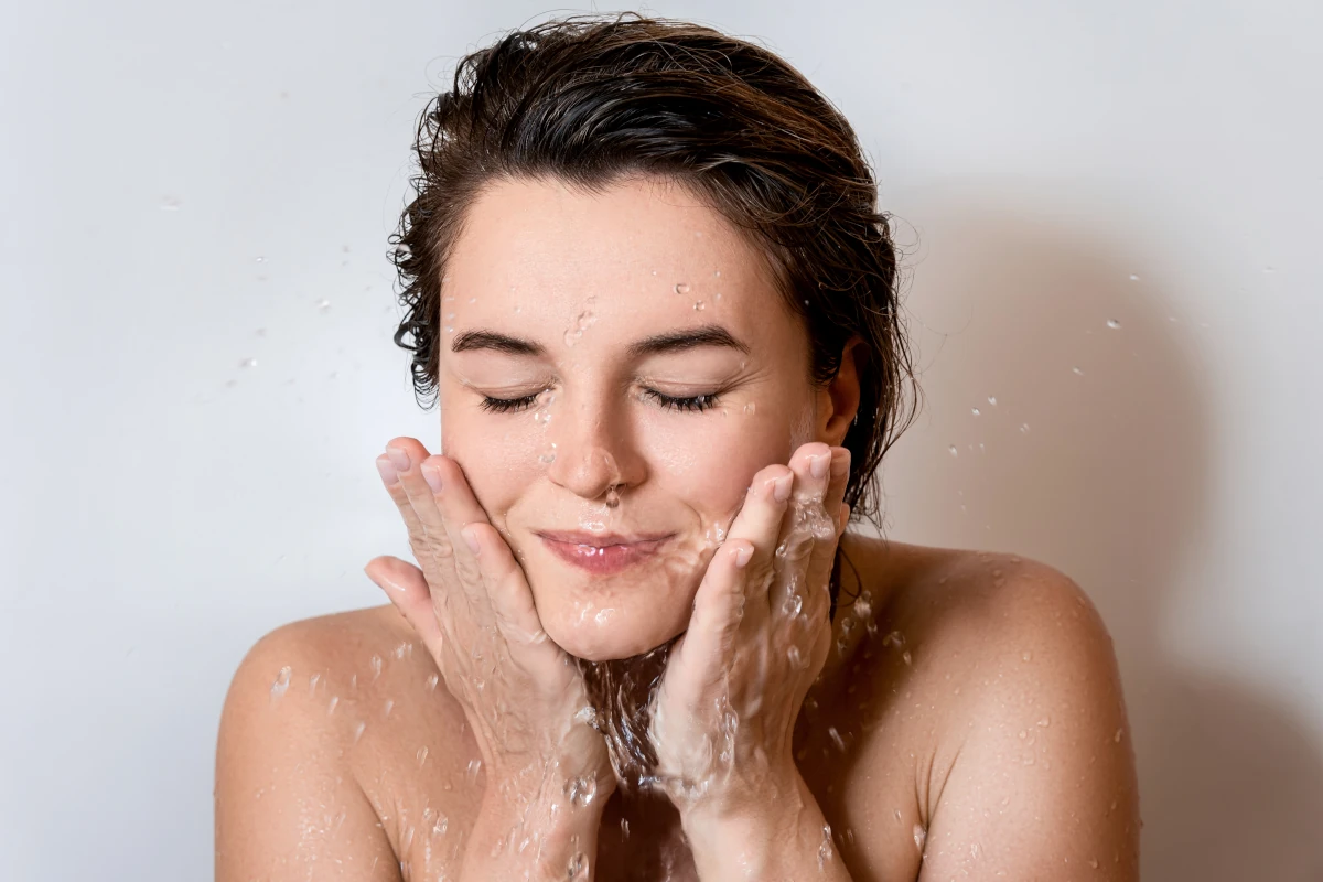 kobieta myje twarz dużą ilością wody