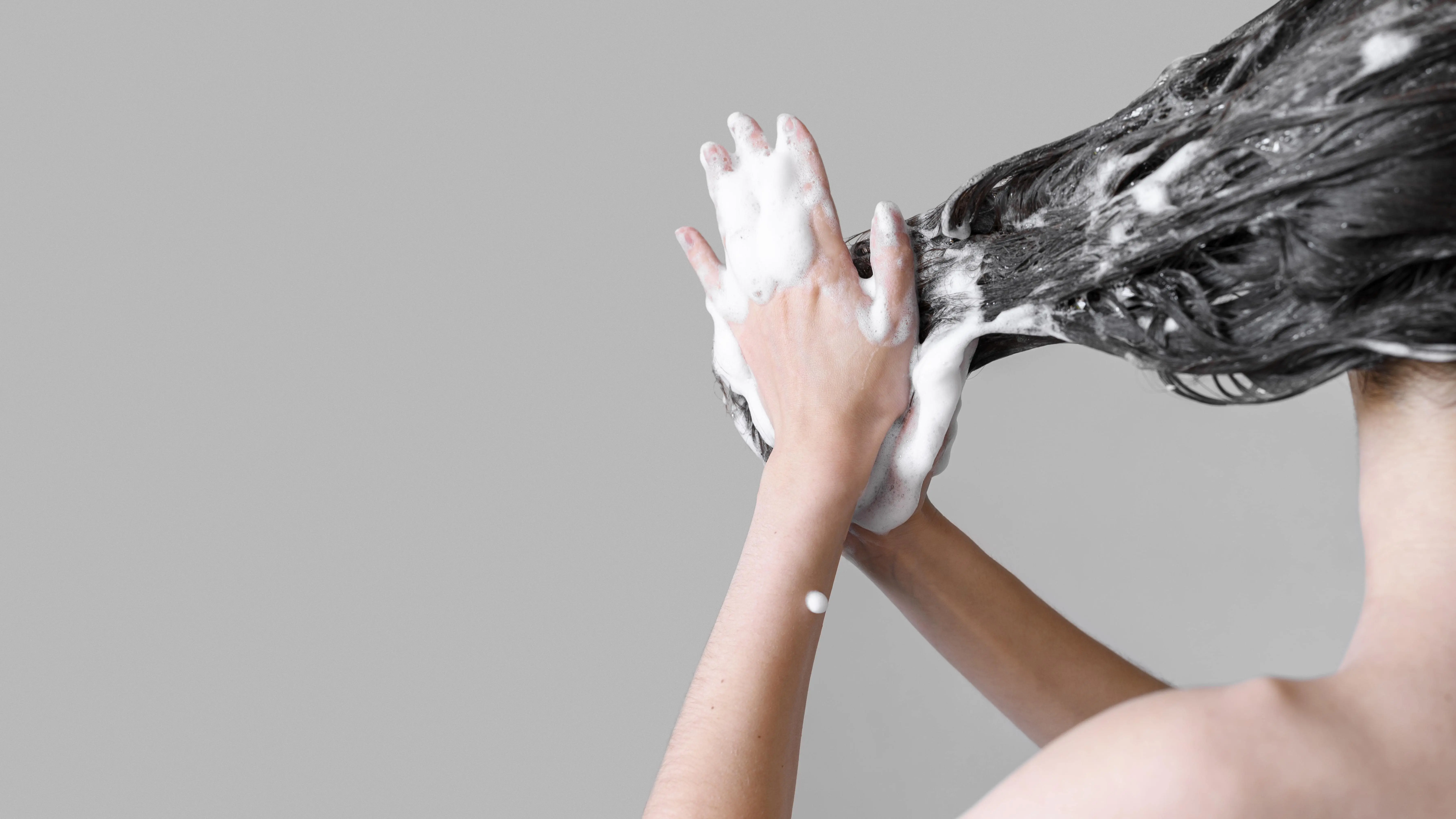 Kobieta myje włosy szamponem